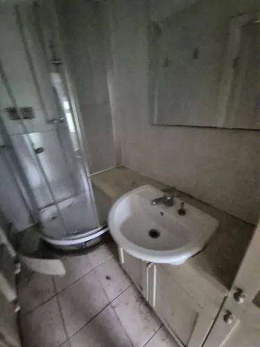 Original shower room with quadrant enclosure, basin on a cupboard and mirror