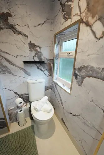 Panelled window reveal and black shelf above the new toilet