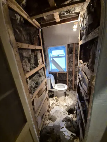WC stripped to timber studs and rubble with the toilet left connected