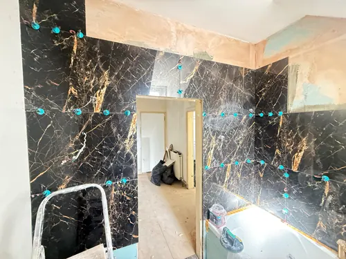 Large-format wall tiles going up either side of the doorway