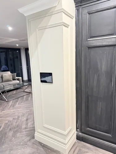 Flush control panel screen set into the painted column beside the dark cabinetry