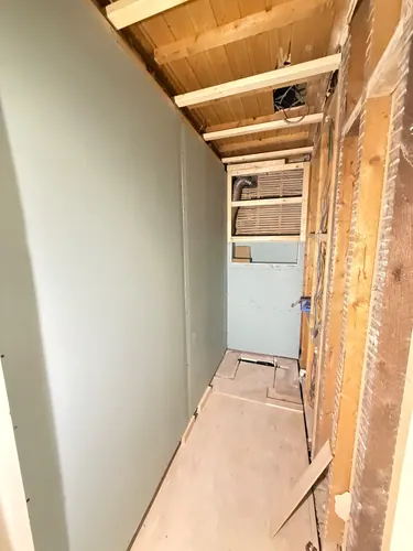 Plasterboarded walls with extract ducting at high level and cables left ready for fittings