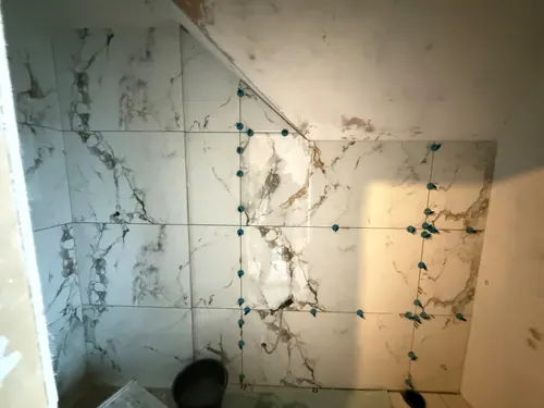 Tiles fitted around the sloping ceiling line of the shower area