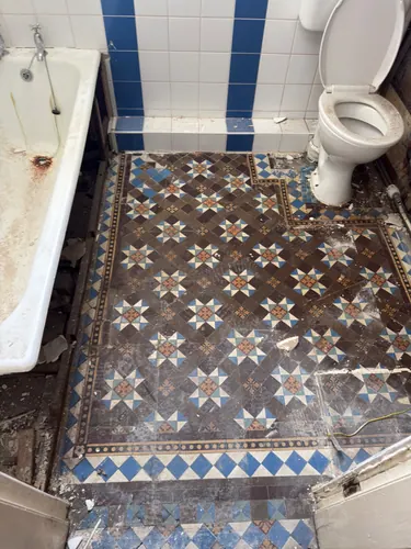 Original patterned tile floor uncovered after the vinyl was lifted