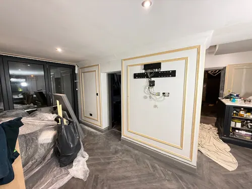 Television bracket and cabling set into an unpainted panelled wall
