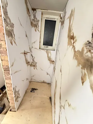 Panelling cut around the window reveal with waste outlet set in the floor