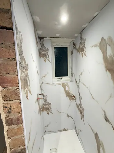 Ceiling downlight fitted above the panelled shower area