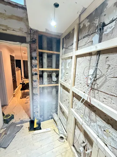 Studwork framing with first fix wiring and soil pipe boxing under way