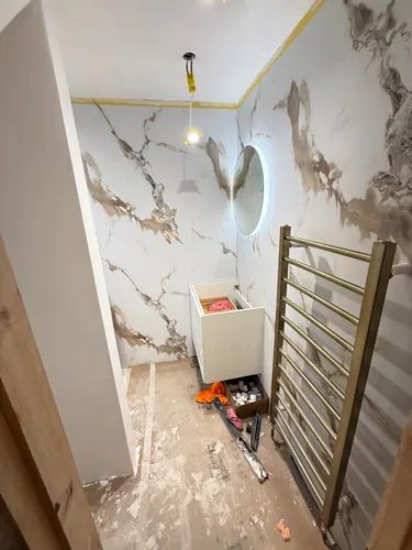 Vanity carcass and illuminated round mirror in place before final fitting
