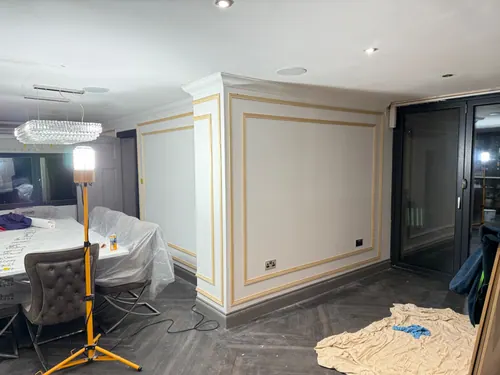 Wide view of dining area with unpainted panel frames across the wall