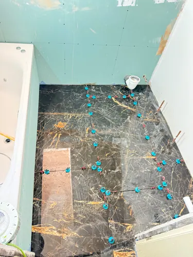 Floor tiling completed with levelling clips still in the joints