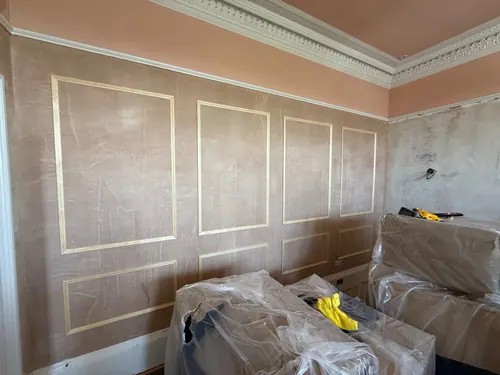 Run of framed panels fitted along the wall under the moulded cornice