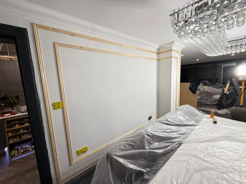 Filled and taped panel mouldings beside the chandelier over the dining table