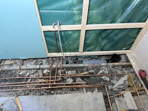 Copper hot and cold pipe runs and waste pipe below the lifted floor