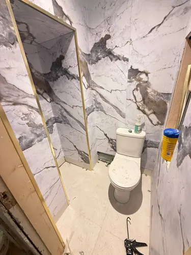 Marble-effect panelling and brass trims fitted in the WC before final cleaning