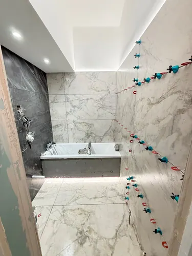 Wall tiling in progress with concealed ceiling lighting switched on