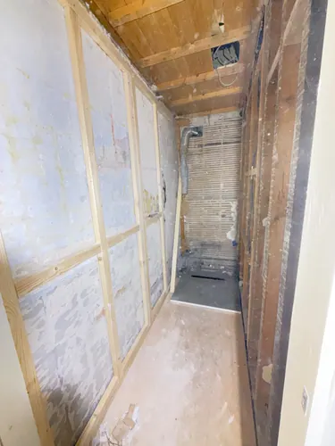 Timber studwork framed against the stripped walls with the floor decked out