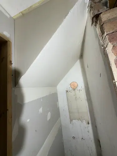 Boarded and skimmed partition with downlight hole cut in the ceiling