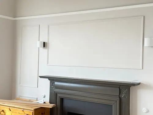 Panel above the original fireplace with wall lights fitted either side